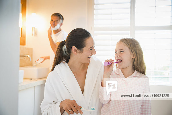 Mutter und Tochter beim Zähneputzen im Bad