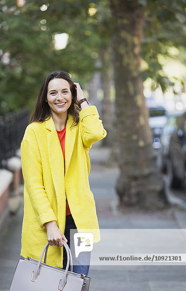 Portrait smiling woman on sidewalk