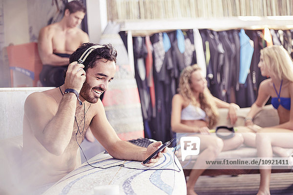 Lächelnder Surfer beim Musikhören mit Kopfhörer und mp3-Player