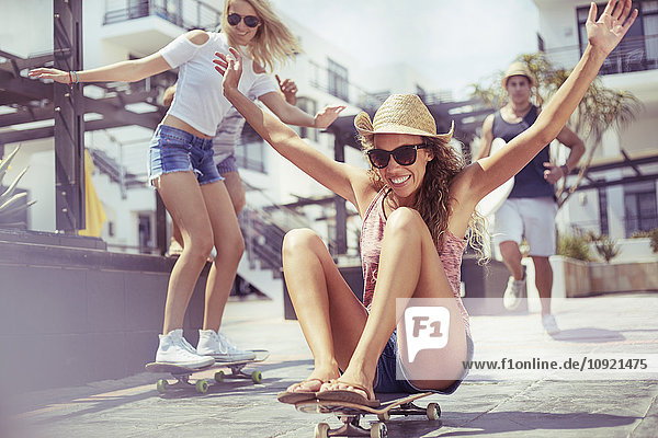 Verspielte junge Frau beim Skateboardfahren