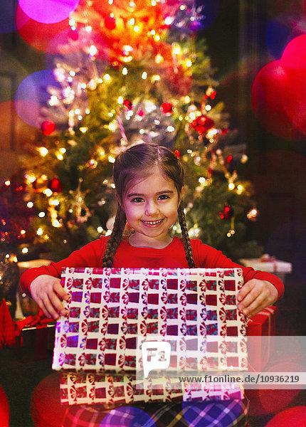 Portrait lächelndes Mädchen eröffnet Weihnachtsgeschenk