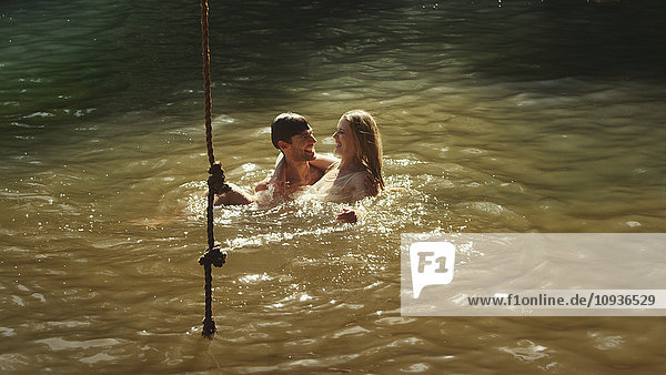 Junges Paar schwimmt im sonnigen See