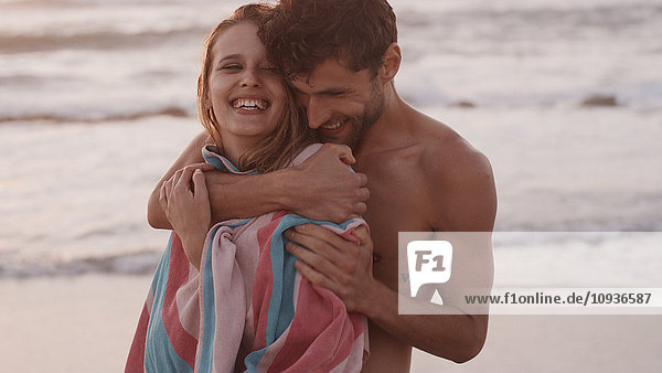 Affectionate young couple hugging on beach
