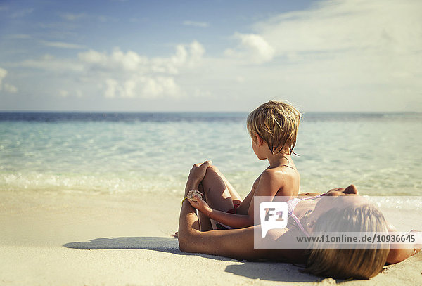 Mutter und Sohn liegen und entspannen am tropischen Strand