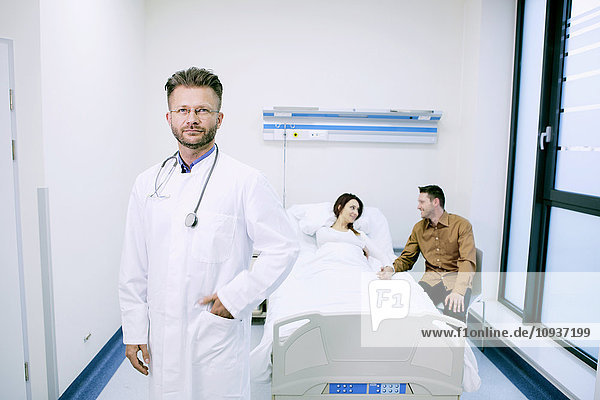 Doctor with patient in sick room of hospital