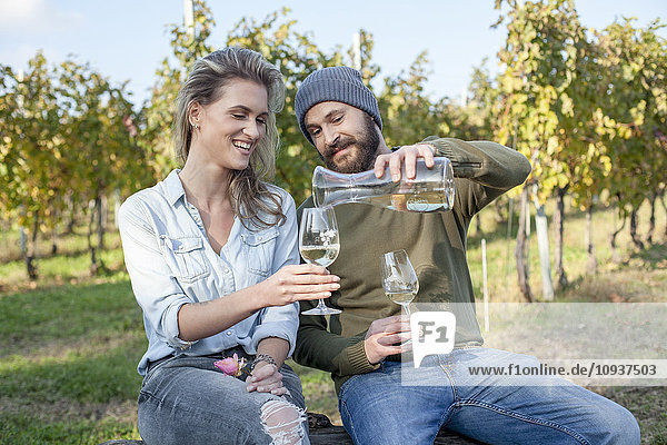 Couple drinking white wine on garden party in vineyard