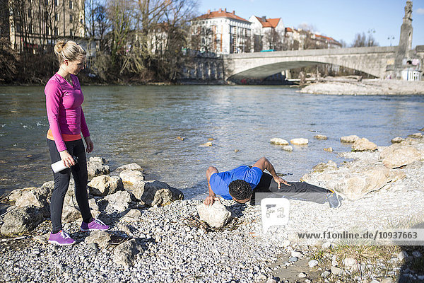 Young couple exercising by the riverside