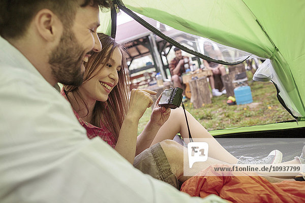 Young couple in a tent looking at camera