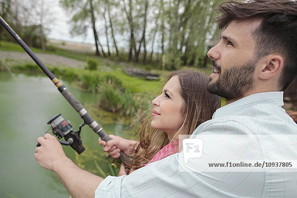 Young couple fishing together in lake