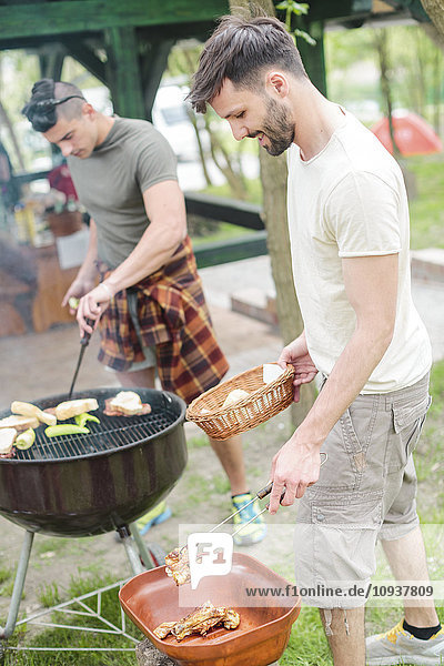 Group of friends having barbecue at campsite