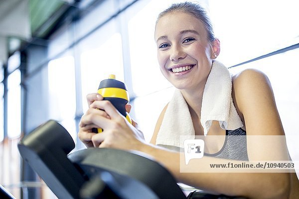Frau hält Wasserflasche im Fitnessstudio