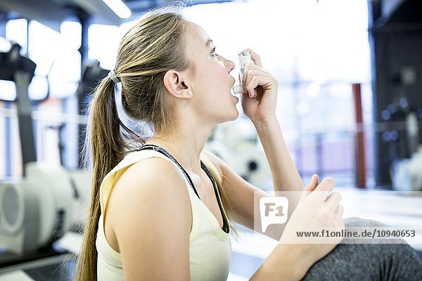 Young woman using inhaler
