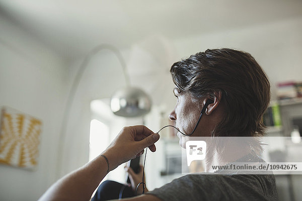 Side view of architect talking through in-ear headphones at home