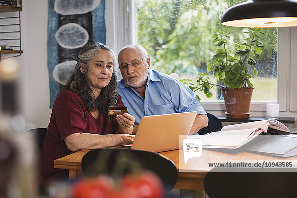 Senior Paar mit Kreditkarte für die Online-Zahlung auf dem Laptop zu Hause