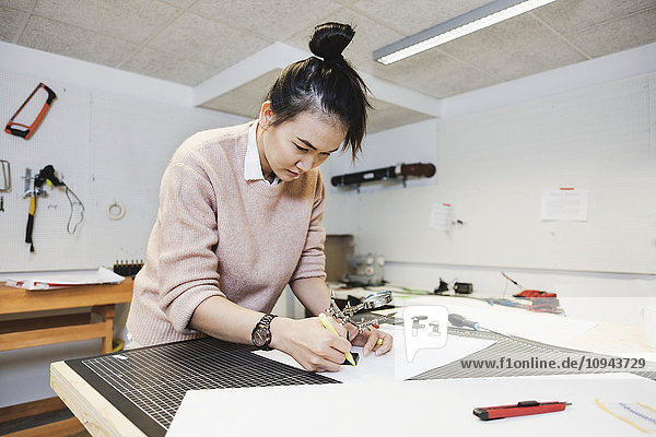 Businesswoman planning on paper at table in creative office