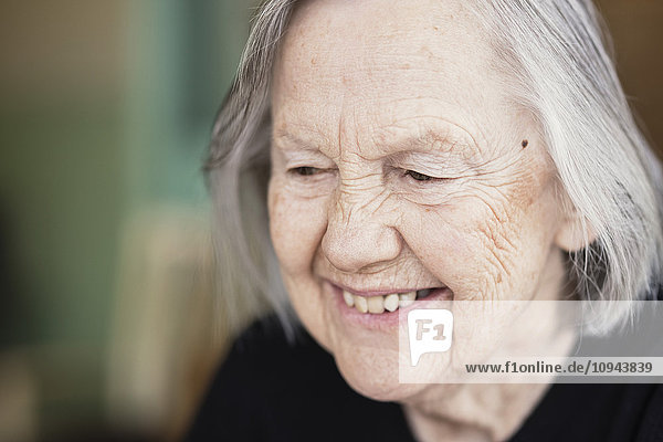 Nahaufnahme einer lächelnden Seniorin im Pflegeheim