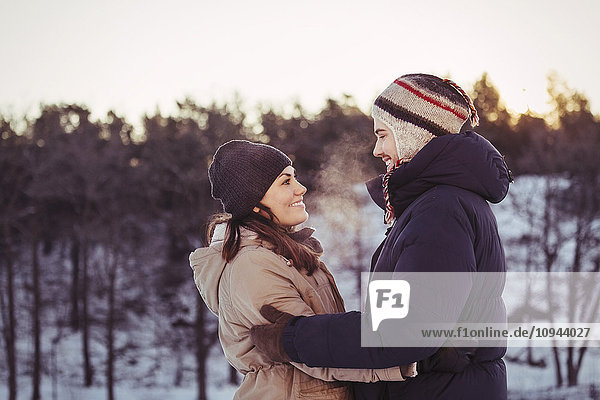 Happy couple embracing on field during winter