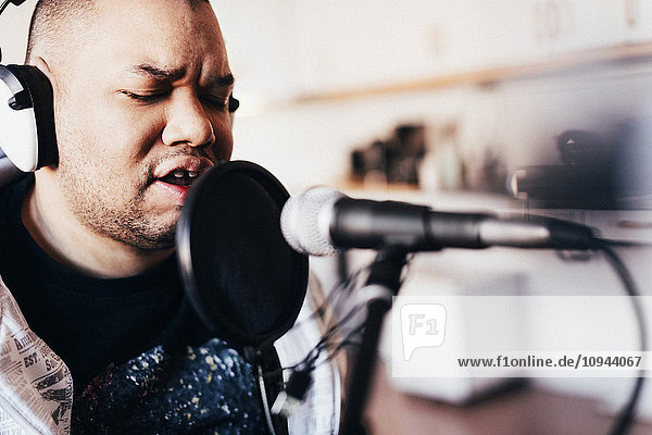 Behinderte männliche Sängerin beim Singen im Aufnahmestudio