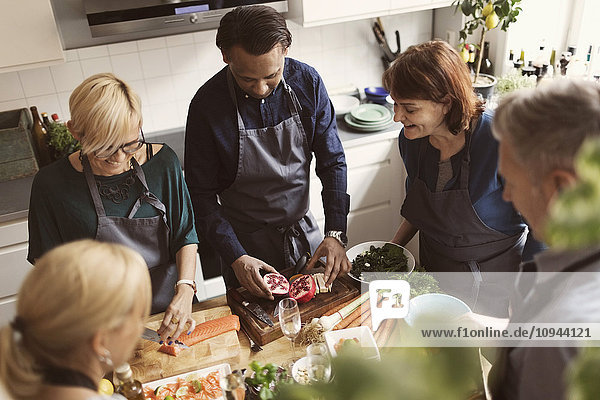 Hochwinkelansicht von multiethnischen Freunden bei der Zubereitung von Speisen in der Küche