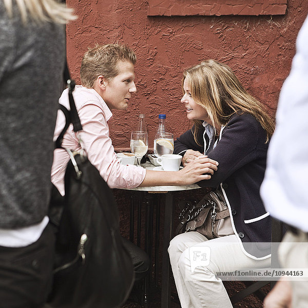 Mittleres erwachsenes Paar im Straßencafé beim Reden