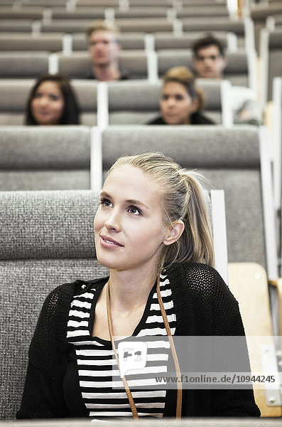 Close up of beautiful young woman sitting in auditorium