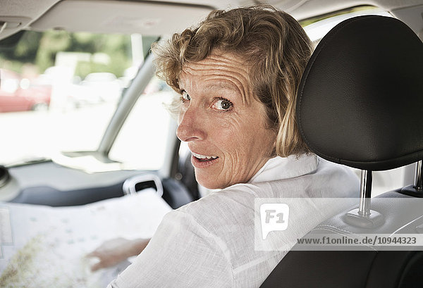 Reife Frau beim Sitzen im Auto über die Schulter schauen