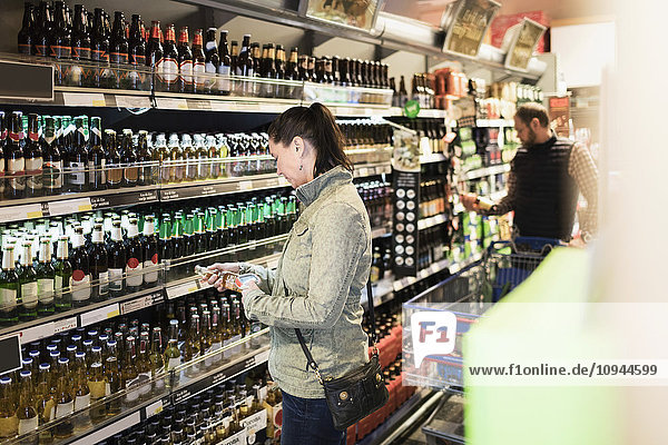 Kundin scannt Bierflasche im Supermarkt