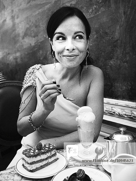 Frau isst Dessert in einem Straßencafé