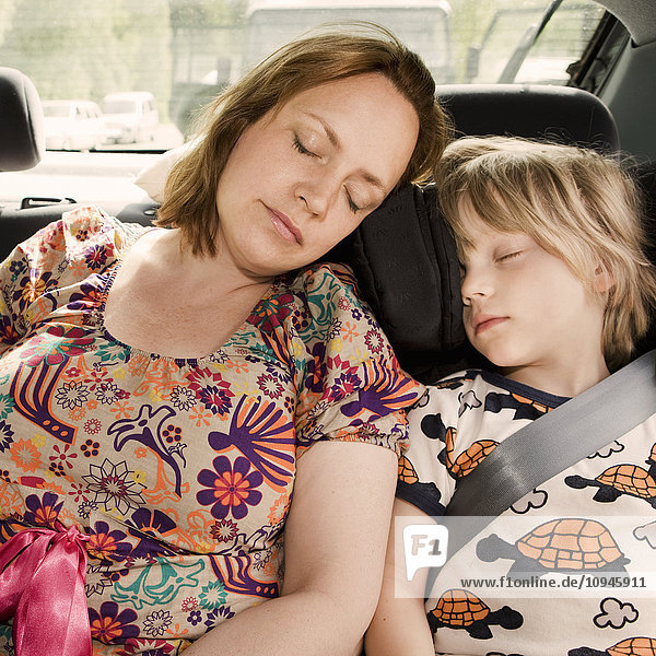 Mother and son sleeping inside car