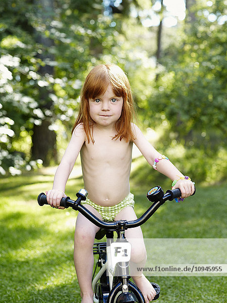 Girl cycling in back yard