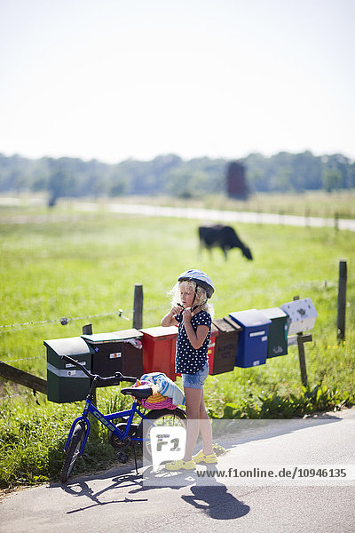 Girl wearing cycling helmet standing on road