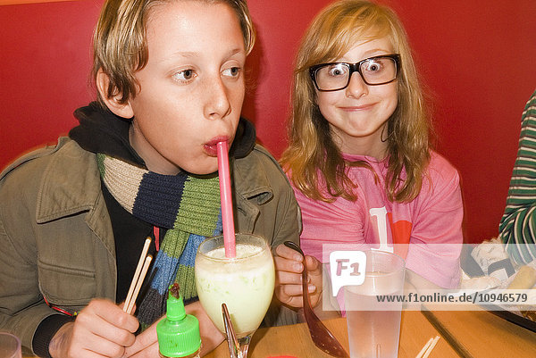 Boy and girl sitting at restaurant table