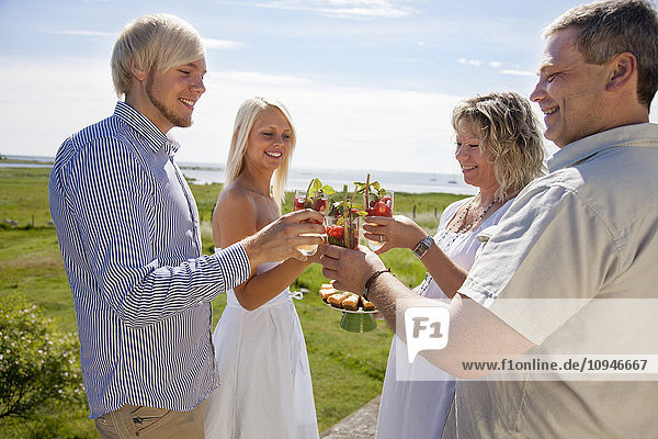 Couples toasting drink at coast  smiling