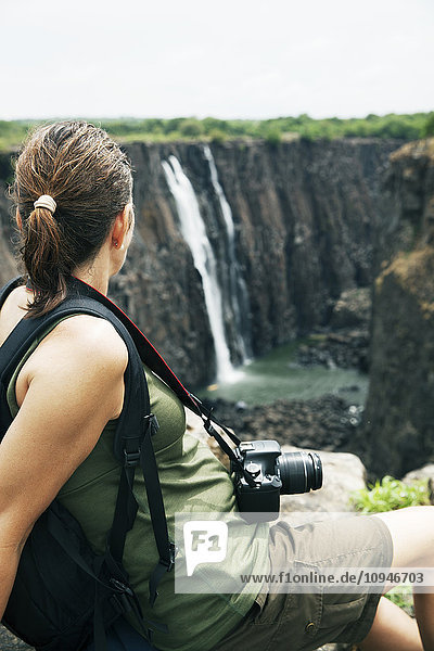 Frau schaut auf Wasserfall