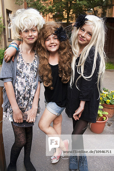 Porträt von drei Mädchen mit Perücken