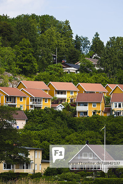 Häuser auf einem Hügel zwischen Bäumen