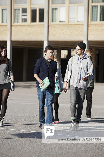 Teenagers walking on schoolyard