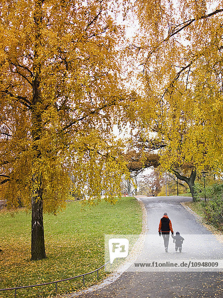 Mother with child walking through autumn park