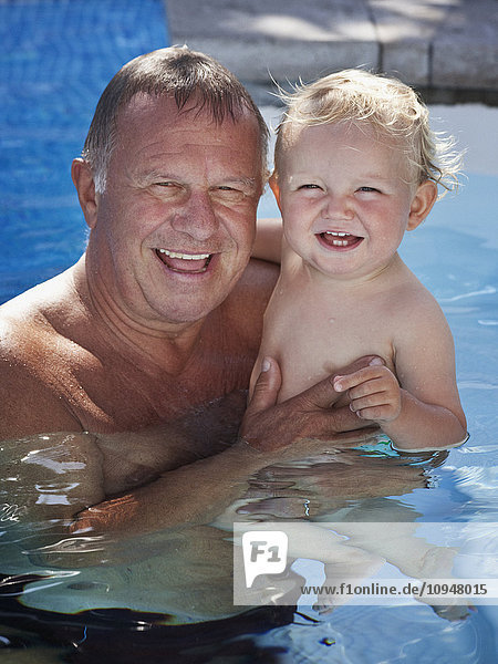 Porträt eines Großvaters mit Enkel im Schwimmbad