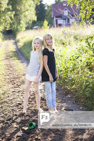 Zwei Mädchen stehen auf einer Landstraße
