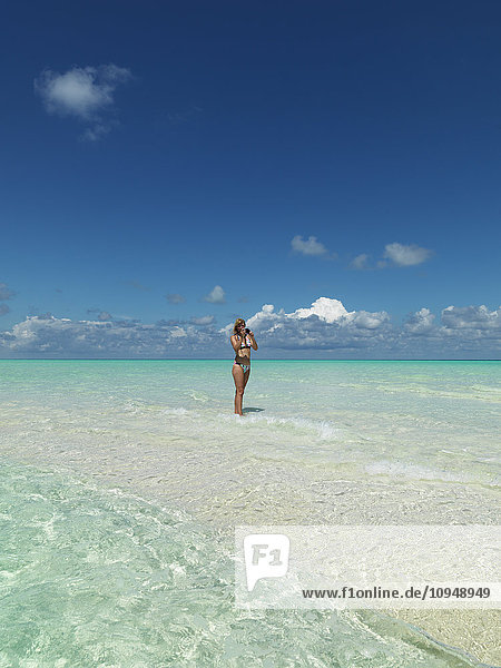 Frau macht Fotos am tropischen Strand