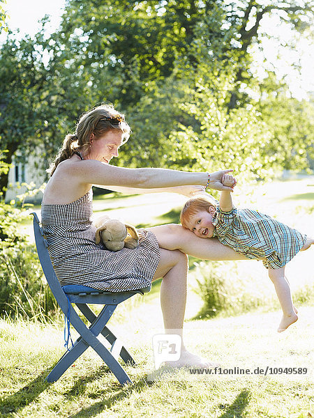 Mother playing with daughter outdoors