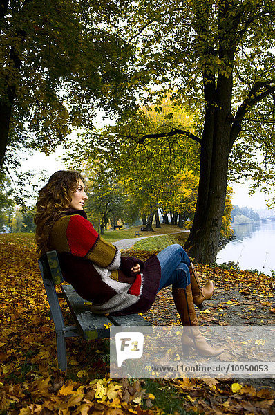 Eine Frau sitzt auf einer Parkbank.