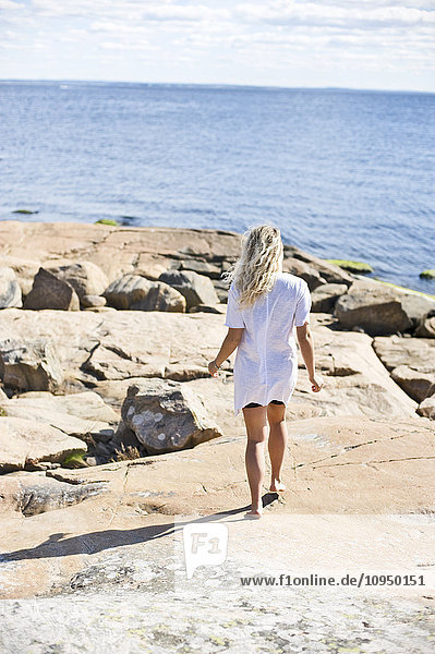 Junge Frau geht an der Küste entlang