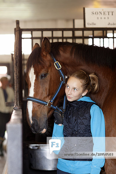 Mädchen mit Pferd im Stall
