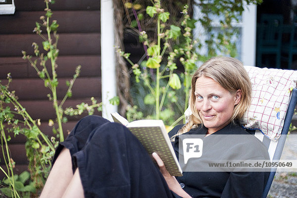 Frau auf Sonnenstuhl mit Buch