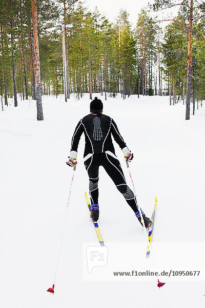 Person beim Skifahren im Wald