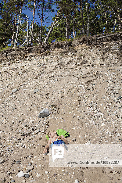 Boy lying on sand