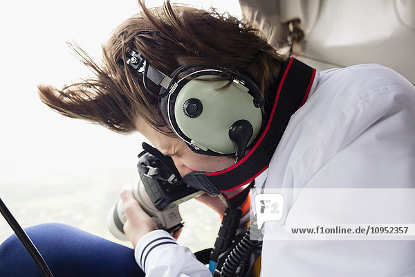 Jugendlicher im Hubschrauber beim Fotografieren