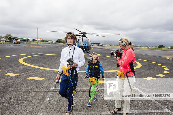 Mutter mit Söhnen vor einem Hubschrauber